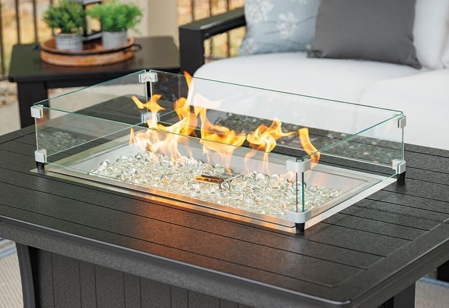 Black poly lumber coffee table with a fire pit and safety glass in the center.