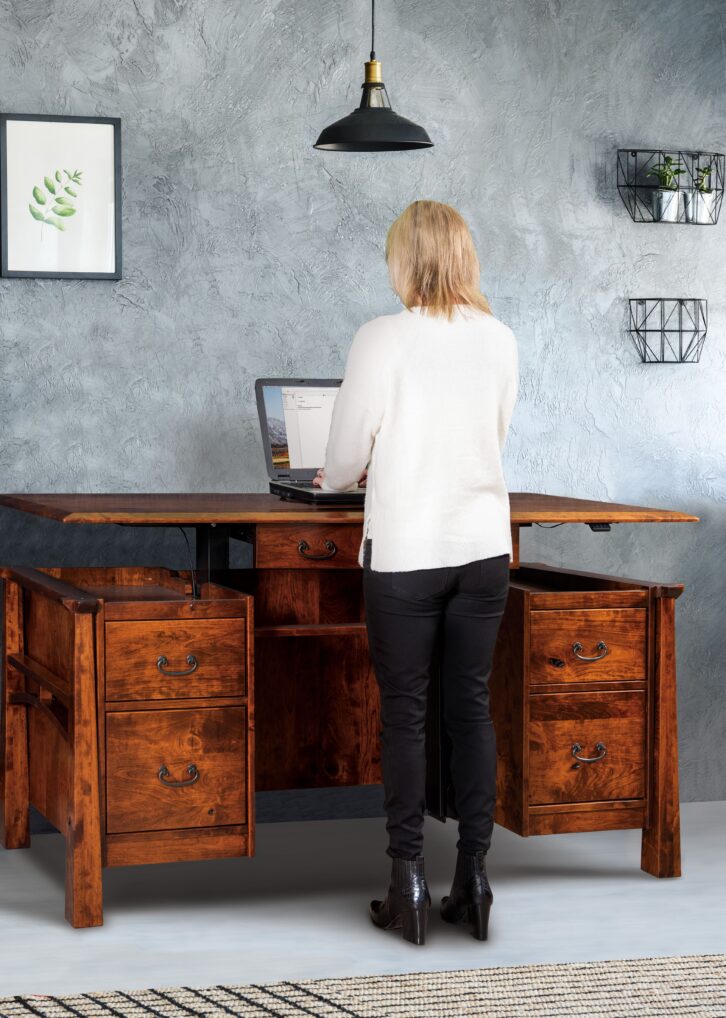 woman in front of an artesa sit to stand desk in an office