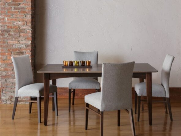 A brown hardwood dining table with 4 gray upholstered dining chairs.