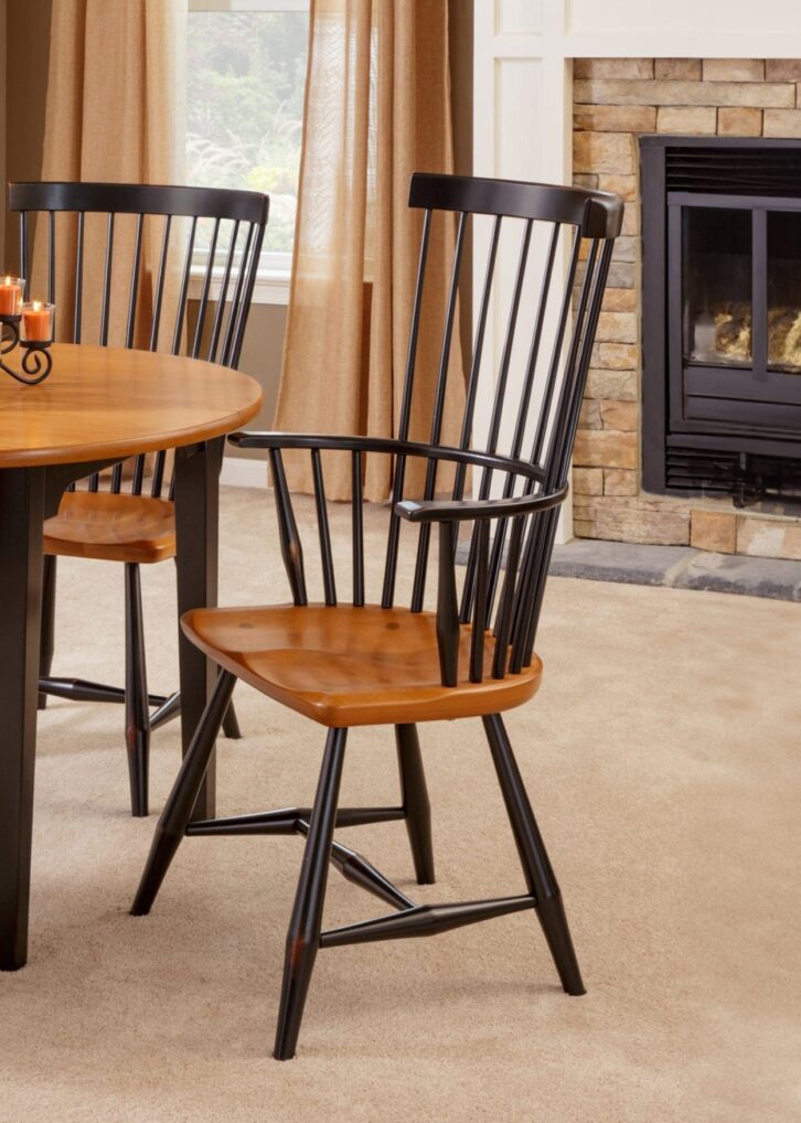 Brown and black hardwood dining set with a round dining table and 3 matching dining chairs.
